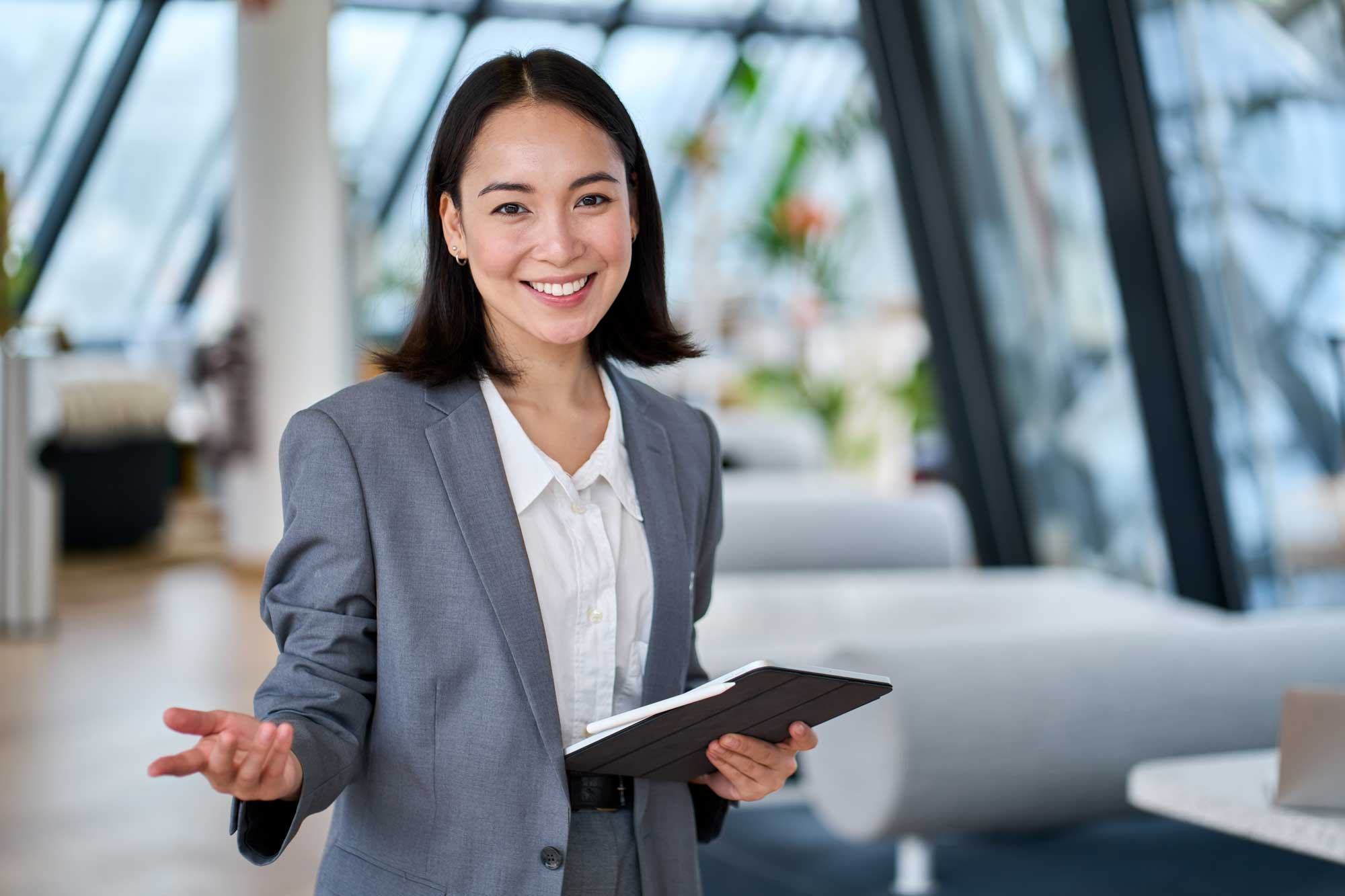 Happy young Asian saleswoman looking at camera